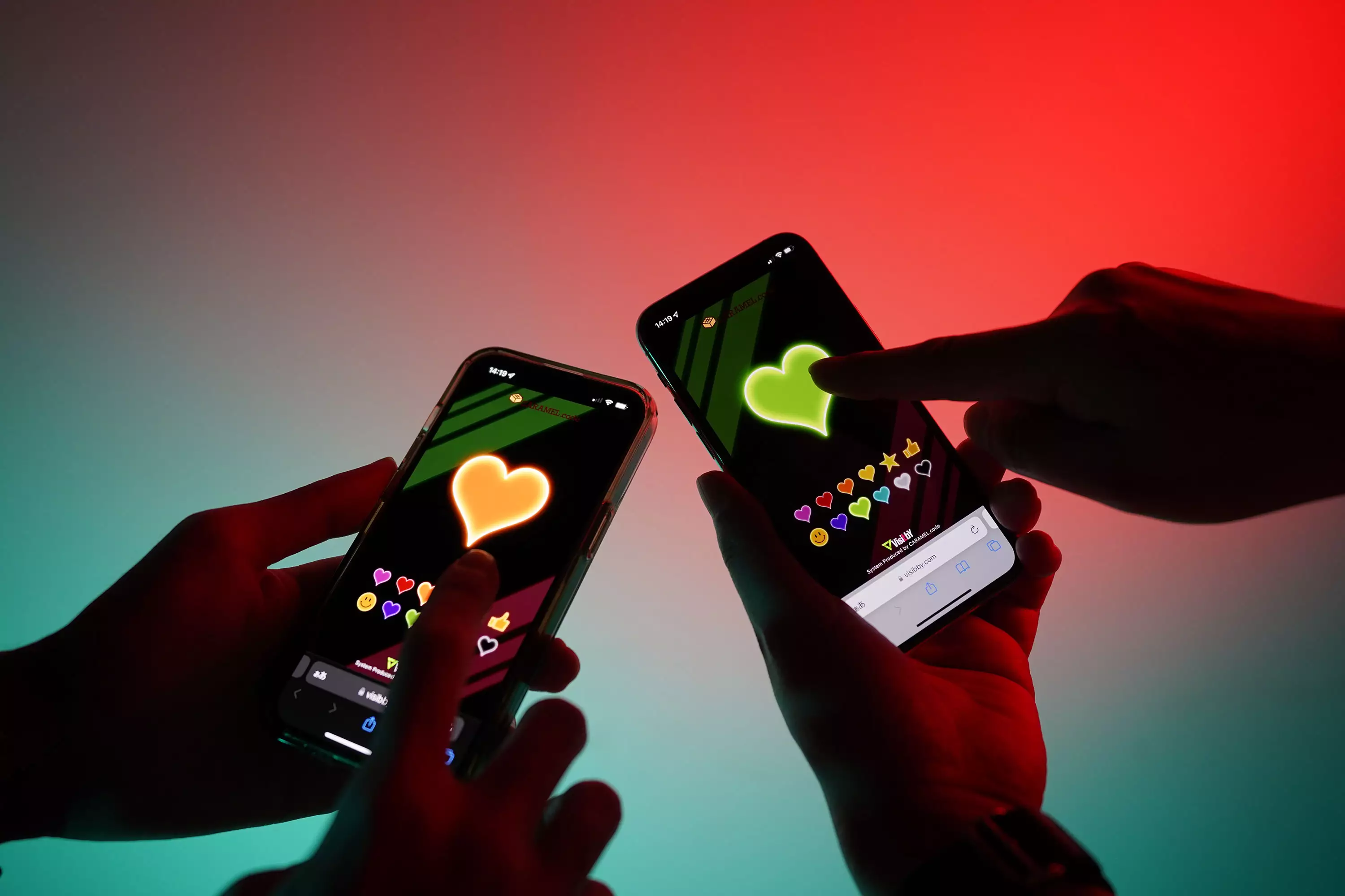 Two people press heart stamps on the Visibby smartphone screen.